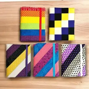 Celebrate Pride Month with D-Marie’s Sweet Threads' vibrant collection of fabric-covered composition notebooks inspired by Pride flags.