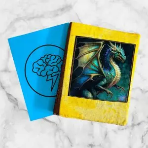 Dragon Fyre notebook cover featuring a majestic blue dragon with shimmering scales on a yellow background and a yellow elastic band.