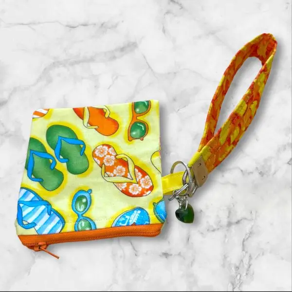 A Summer Vibes Wristlet Key Fob and Card Wallet with colorful flip-flops and sunglasses patterns.