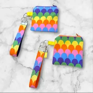 Dive into a sea of vibrant colors with the Rainbow Scales Wristlet Key Fob & Card Wallet. This playful design features a stunning array of bright hues arranged in a fun, scale-like pattern. Perfect for those who love bold accessories, this set will keep your essentials secure while adding a splash of color to your day. Key Features: • Made with 100% cotton and durable nylon webbing • Wristlet measures approximately 1.5" x 7" • Zipper pouch measures approximately 4.5" x 4.5" • Ideal for keys, IDs, cards, and small items • Unique pattern placement for a one-of-a-kind look Bring a burst of color into your life with the Rainbow Scales Wristlet and Card Wallet—perfect for adding a touch of fun to any outfit.