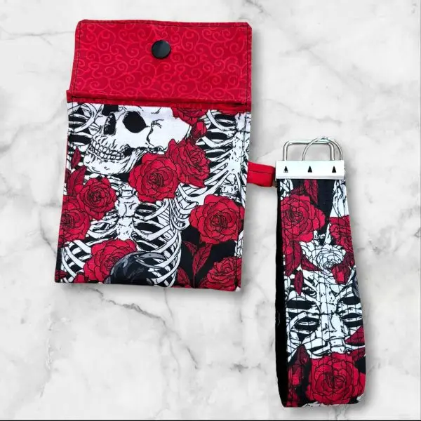 A Gothic Elegance Wristlet Key Fob and Card Wallet with deep red roses and skulls on a black and white background.