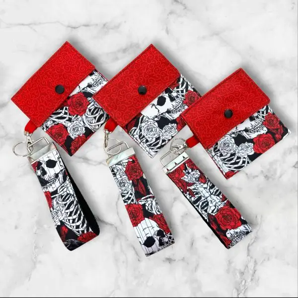 A Gothic Elegance Wristlet Key Fob and Card Wallet with deep red roses and skulls on a black and white background.