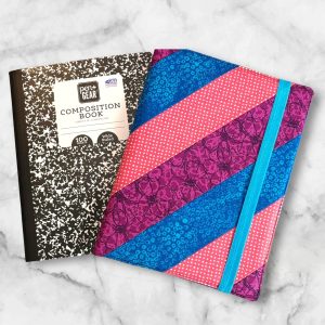 Pink, Purple and Blue Diagonal composition notebook cover with vibrant stripes and a blue elastic band.