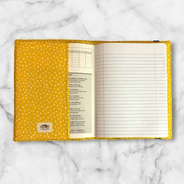 Checkerboard pattern composition notebook cover featuring yellow, white, purple, and black squares with a matching elastic band.