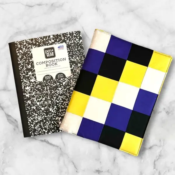 Checkerboard pattern composition notebook cover featuring yellow, white, purple, and black squares with a matching elastic band.