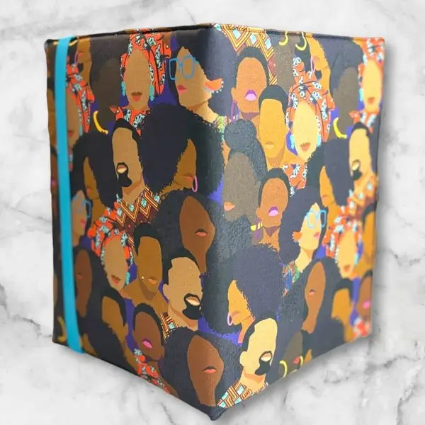 African American Print composition notebook cover featuring powerful Black faces design with a blue elastic band.