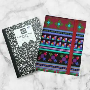 Vibrant geometric composition notebook cover featuring deep reds, greens, purples, and blues with a red elastic band.