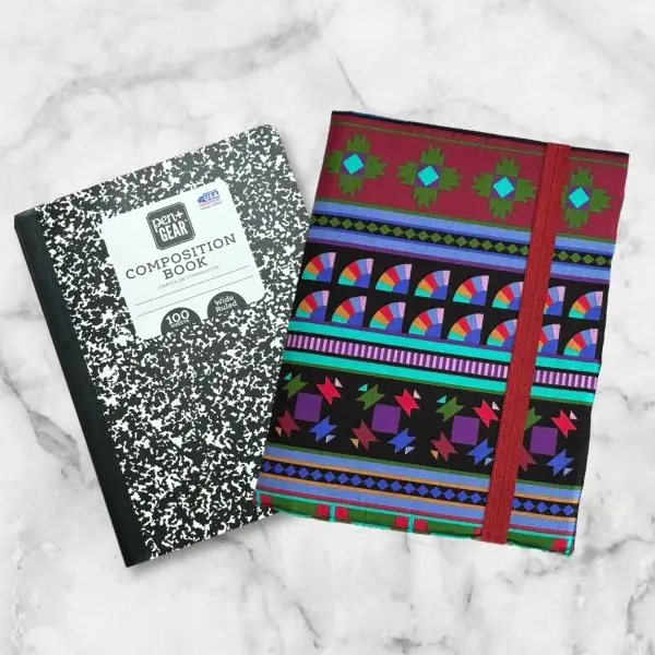 Vibrant geometric composition notebook cover featuring deep reds, greens, purples, and blues with a red elastic band.