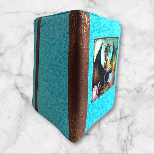 Dragon Fyre composition notebook cover with a majestic dragon on a turquoise background, featuring a brown textured spine.