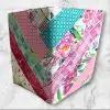 Quilted composition notebook cover with a mix of pink, green, and floral striped patterns, creating a fresh and elegant look.