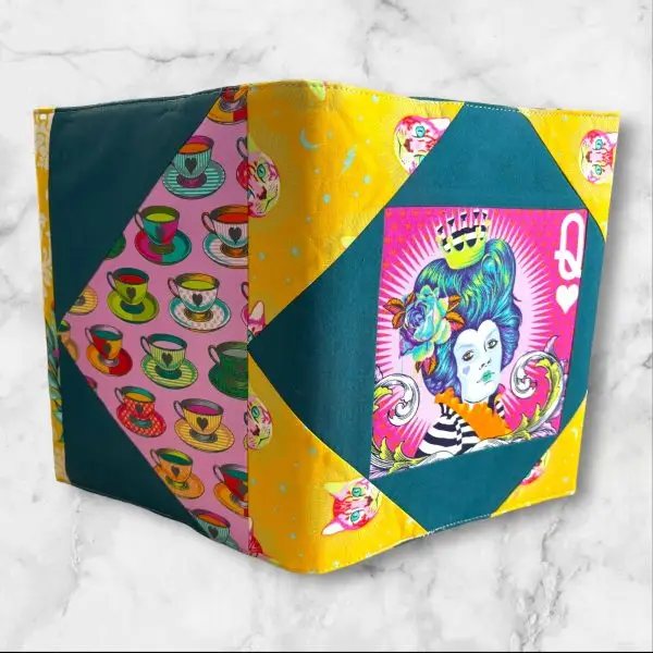 Quilted composition notebook cover with a vibrant, colorful design featuring a Queen of Hearts-inspired illustration in bold, artistic patterns.