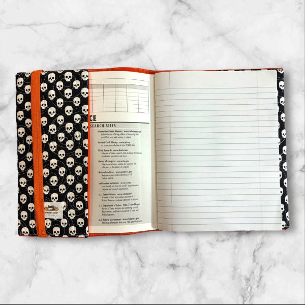 Quilted composition notebook cover in black with white skull print, with "Fang-Tastic" embroidery on the front, is perfect for Halloween or gothic-themed stationery.