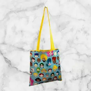 A colorful tote bag featuring a variety of cartoon faces representing diversity, designed by Alexander Henry, celebrating the LGBTQ+ community.