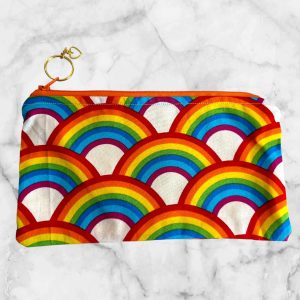 Rainbow Zipper Pouch featuring vibrant rainbow arches and an orange zipper with a heart-shaped charm.