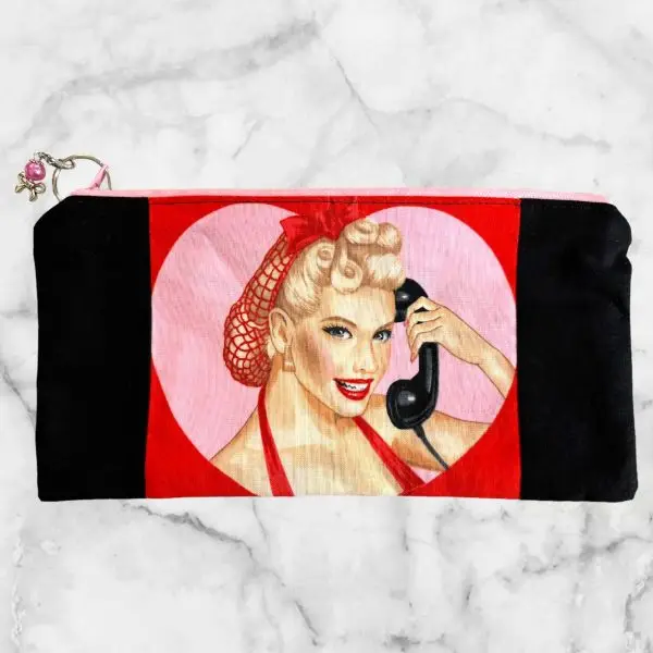 Retro Pin-Up Girl - Dial LOVE Zipper Pouch with a red bow girl illustration, pink zipper, and Girl Talk fabric lining.