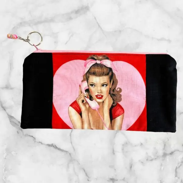 Classic Pin-Up Girl Zipper Pouch with Dial LOVE focus fabric, a pink phone girl illustration, pink zipper, and Girl Talk fabric lining.